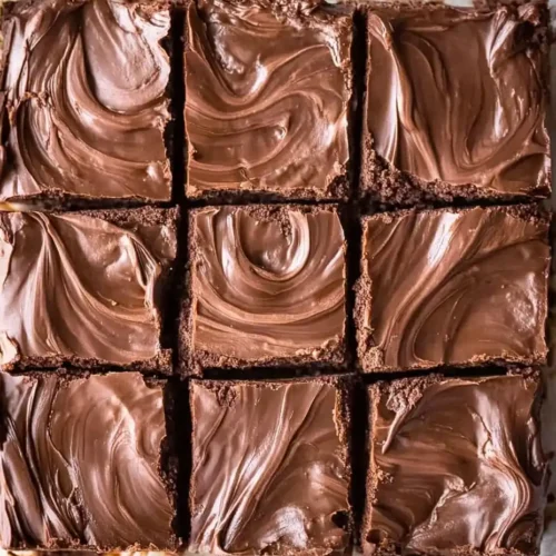 No Bake Nutella Fudge cut into squares with a smooth, swirled chocolate top.